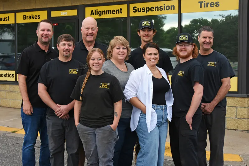 Apple Valley Car Clinic mechanics and staff smiling in front of the shop windows