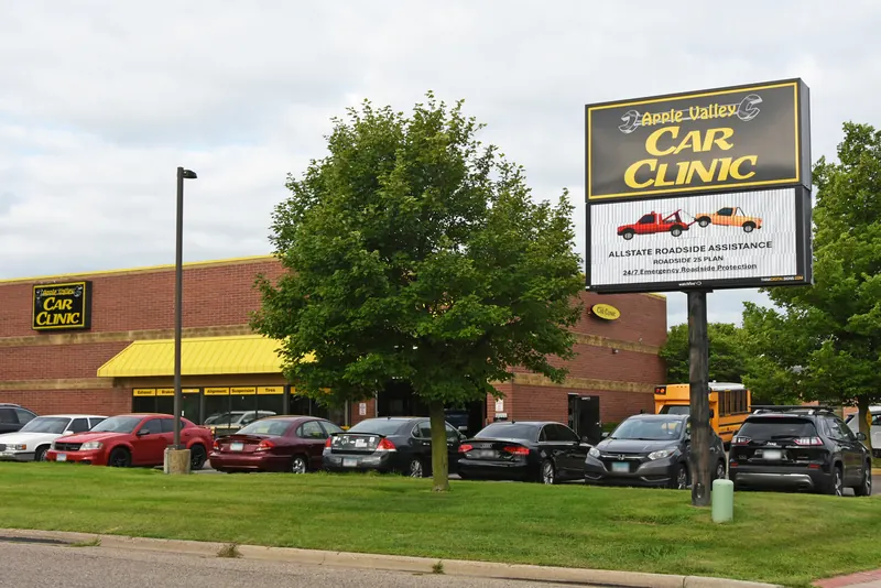 Apple Valley Car Clinic shop and street sign seen from the road in Apple Valley, MN