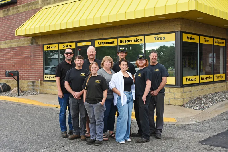 The full Apple Valley Car Clinic team in front of the yellow-awning storefront