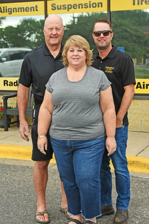 Justin, owner of Apple Valley Car Clinic, with his parents Doug and Karen outside the shop