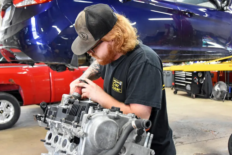 Technician working on an engine cylinder head at Apple Valley Car Clinic